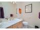 Clean bathroom with a marble countertop vanity, gold fixtures, and decorative artwork at 1831 Rosemere Ct, Las Vegas, NV 89117