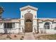 Detailed view of the arched front entrance with double doors, lion statues, and manicured desert landscaping at 1831 Rosemere Ct, Las Vegas, NV 89117