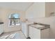 Convenient laundry room equipped with washer, dryer, utility sink, storage, and a window at 1831 Rosemere Ct, Las Vegas, NV 89117