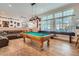 Cozy living room featuring a pool table, comfortable seating, and large windows at 1831 Rosemere Ct, Las Vegas, NV 89117