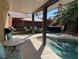 Relaxing backyard pool area with patio seating, palm trees, and a tranquil water feature at 1913 April Mist St, Henderson, NV 89002