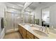 Bathroom with double sinks, a large mirror, and a glass-enclosed shower at 2858 Red Arrow Dr, Las Vegas, NV 89135