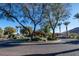 Circular community entrance featuring mature trees, palms, and pristine landscaping at 2858 Red Arrow Dr, Las Vegas, NV 89135