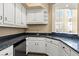 Wet bar features dark granite counters, white cabinets, and stainless appliances at 2858 Red Arrow Dr, Las Vegas, NV 89135