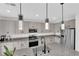 Well-lit kitchen with modern lighting fixtures, granite countertops, and stainless steel appliances at 2865 Victorian Rd, North Las Vegas, NV 89086