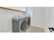 Convenient laundry room featuring a front-load washer and dryer set with white cabinets above and tile flooring at 2865 Victorian Rd, North Las Vegas, NV 89086