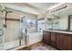 Bathroom with tiled shower, soaking tub, dual sinks, and dark wood cabinets at 336 S Milan St, Henderson, NV 89015