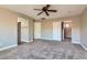 Bedroom with ceiling fan and arched doorway to bathroom, with carpet at 336 S Milan St, Henderson, NV 89015