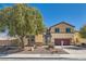Attractive two-story home with a well-maintained lawn, mature tree, and a two-car garage at 336 S Milan St, Henderson, NV 89015