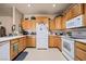 A well-lit kitchen features wood cabinets, white appliances, and a tiled floor at 341 Grapevine Rd, Mesquite, NV 89027