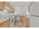 Open kitchen with wood cabinets, white countertops and appliances, flowing into the living area at 3672 Angela Robin St # 206, Las Vegas, NV 89129