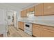 Galley kitchen featuring white appliances, laminate countertops, and wood cabinets at 3672 Angela Robin St # 206, Las Vegas, NV 89129
