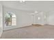 Carpeted living room with an arched window, neutral walls, and modern lighting at 3672 Angela Robin St # 206, Las Vegas, NV 89129