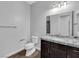 A modern bathroom with a granite countertop vanity, toilet, and chrome hardware at 380 Baratheon Ave, Las Vegas, NV 89183