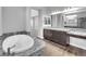 Bathroom featuring marble counters, large tub, and dark wood cabinets at 380 Baratheon Ave, Las Vegas, NV 89183