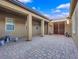 Charming courtyard with brick pavers, covered seating area, and double-door entry at 380 Baratheon Ave, Las Vegas, NV 89183