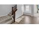 Inviting entryway with wood-look tile flooring, carpeted stairs with dark wood banister, and plenty of natural light at 380 Baratheon Ave, Las Vegas, NV 89183