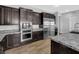A gourmet kitchen boasting dark wood cabinets, stainless steel appliances, and granite countertops at 380 Baratheon Ave, Las Vegas, NV 89183