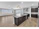 Open-concept kitchen featuring a spacious island with dark cabinets, stainless appliances and tile floors at 380 Baratheon Ave, Las Vegas, NV 89183