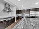 Open kitchen with large granite island, stainless steel appliances and custom cabinetry at 380 Baratheon Ave, Las Vegas, NV 89183