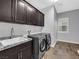 Functional laundry room with modern washer and dryer, granite countertops, and storage cabinets at 380 Baratheon Ave, Las Vegas, NV 89183