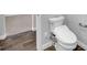 Close-up of modern toilet in a bathroom with wood-look floors and neutral paint at 380 Baratheon Ave, Las Vegas, NV 89183