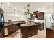 Kitchen with granite countertops, island, dark wood cabinetry, and stainless appliances at 3823 Chapels Royal St, Laughlin, NV 89029