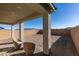 Covered patio featuring stylish lounge chairs, textured brick floors, and an expansive backyard with desert landscape at 3921 Painted Lady Ave, Las Vegas, NV 89141