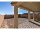 Covered patio with sleek pillars and a textured brick floor, overlooking a spacious backyard with desert landscape at 3921 Painted Lady Ave, Las Vegas, NV 89141