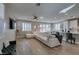 Bright living space featuring an oversized white sectional, wood-look tile floor, and seamless flow to the kitchen at 3921 Painted Lady Ave, Las Vegas, NV 89141