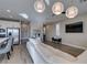 Bright living room with a large white sofa, wood-look tile floors, and a stylish pendant lighting fixture at 3921 Painted Lady Ave, Las Vegas, NV 89141