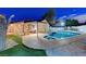 Expansive backyard showcasing a sparkling pool, covered patio, lounge seating, and lush greenery at 4055 Planetary Ln, Las Vegas, NV 89115