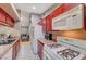 Close-up of kitchen with red cabinets and white appliances at 4055 Planetary Ln, Las Vegas, NV 89115