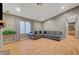 Bright living room featuring a plush sectional, hardwood flooring, and natural light from the window at 4055 Planetary Ln, Las Vegas, NV 89115