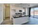 Modern kitchen with white cabinets, dark countertops, stainless steel microwave and island with breakfast bar at 4141 Coburn St, North Las Vegas, NV 89032