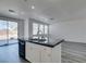 Kitchen island with dark countertop, double sink and stainless faucet overlooking a living area and slider door at 4141 Coburn St, North Las Vegas, NV 89032