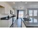 Kitchen with white cabinets, stainless steel appliances, dark countertops and adjacent dining area at 4141 Coburn St, North Las Vegas, NV 89032