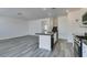 Open-concept kitchen with stainless steel appliances, granite countertops, and light wood flooring at 4141 Coburn St, North Las Vegas, NV 89032