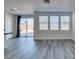 Bright living room featuring sliding glass doors to the backyard, multiple windows and gray wood-look flooring at 4141 Coburn St, North Las Vegas, NV 89032