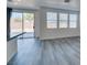 Open living area featuring sliding glass doors to the backyard, multiple windows and gray wood-look flooring at 4141 Coburn St, North Las Vegas, NV 89032