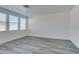 Spacious living room with multiple windows and gray wood-look flooring at 4141 Coburn St, North Las Vegas, NV 89032