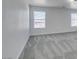 View of a room with neutral carpet, baseboards and two windows dressed with horizontal blinds for natural light at 4141 Coburn St, North Las Vegas, NV 89032