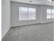 View of a room with neutral carpet, baseboards and two windows dressed with horizontal blinds for natural light at 4141 Coburn St, North Las Vegas, NV 89032