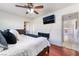 Comfortable bedroom featuring wood floors, a ceiling fan and a wall-mounted TV at 4258 E Twain Ave, Las Vegas, NV 89121