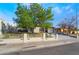 Charming single-story home featuring a well-manicured lawn and a quaint fence, complemented by a lush tree at 4258 E Twain Ave, Las Vegas, NV 89121