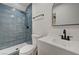 A remodeled bathroom features new shower with blue tile, modern fixtures, toilet, and vanity at 4804 El Tesoro Ave, Las Vegas, NV 89121