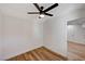 A bright bedroom featuring wood-look flooring, ceiling fan, and a white door at 4804 El Tesoro Ave, Las Vegas, NV 89121