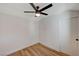 Bright bedroom with wood-look flooring, ceiling fan, and a door to the hall at 4804 El Tesoro Ave, Las Vegas, NV 89121