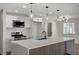 A well-lit kitchen with modern island pendant lights, stainless steel appliances, and white cabinetry at 4804 El Tesoro Ave, Las Vegas, NV 89121