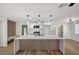 Bright, open kitchen with a large island, modern lighting, white cabinetry, and stainless steel appliances at 4804 El Tesoro Ave, Las Vegas, NV 89121